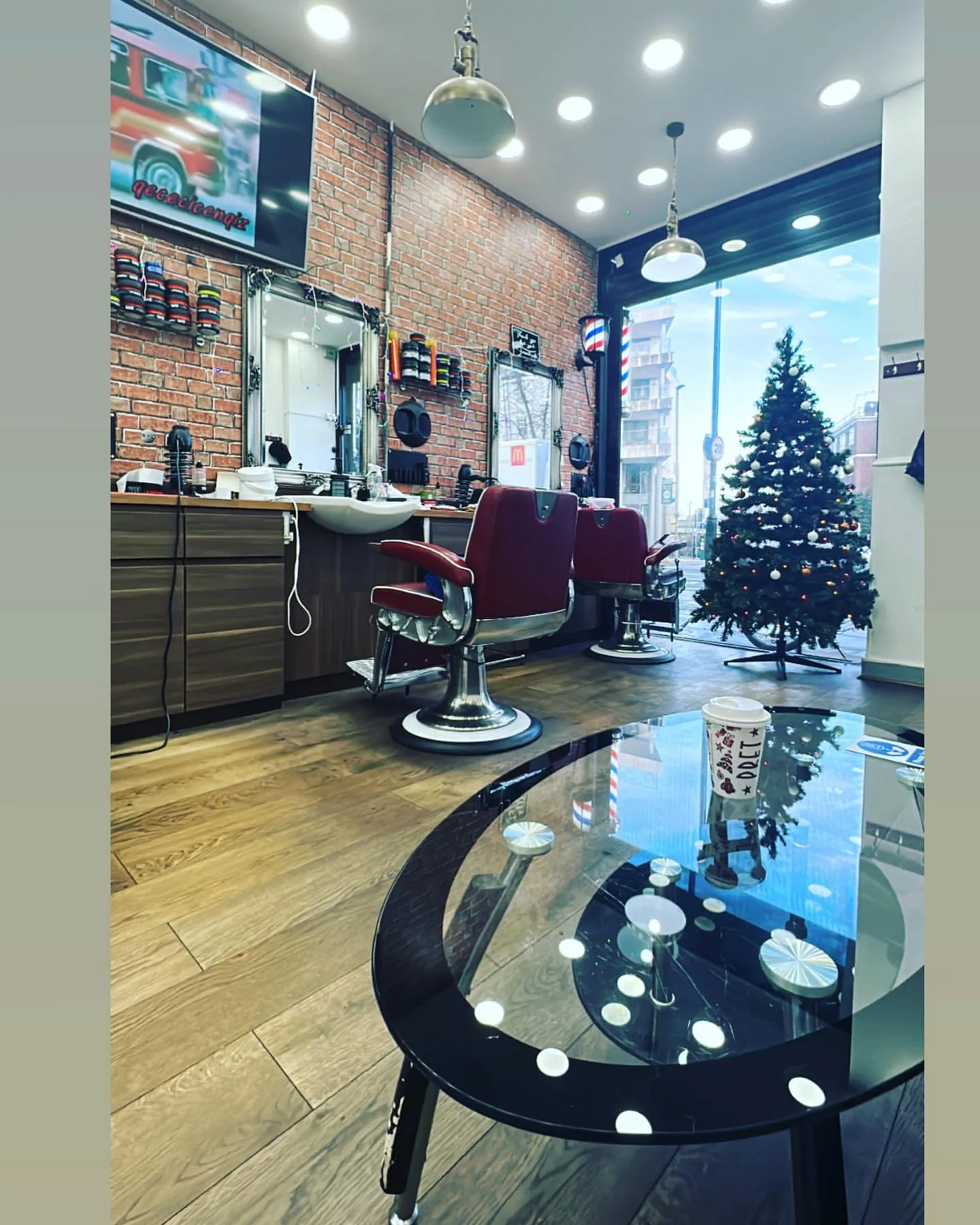 The shop floor: red chairs, brick walls and a glass table